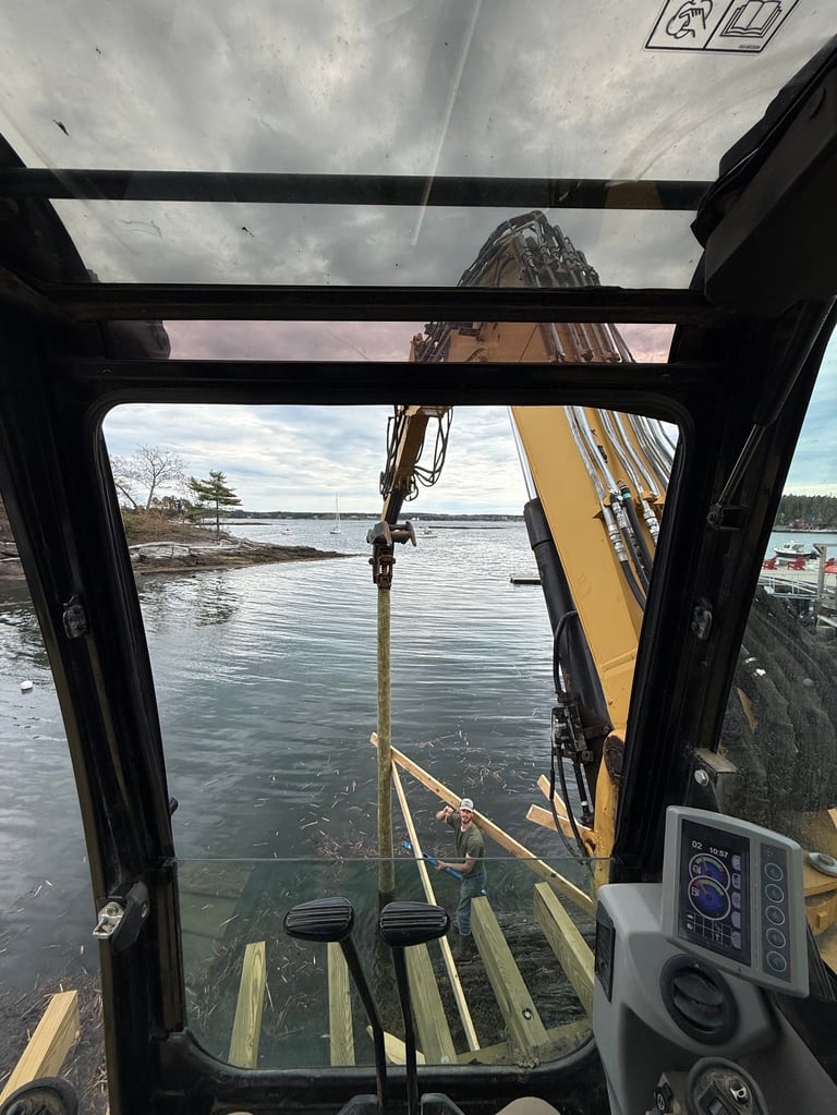 View from inside a cabin cruiser cockpit looking out at a sailboat mast and rigging suspended over the water